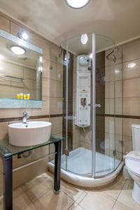 a bathroom with a shower and a sink and a toilet at Areti Suites in Kathiana