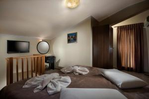 a bedroom with a bed with towels on it at Areti Suites in Kathiana +37 photos