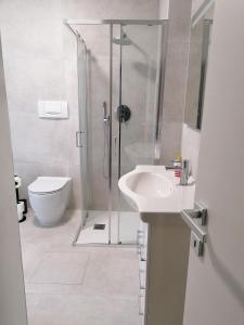 a bathroom with a shower and a sink and a toilet at Ferienhaus Picobello in Zentrum von Marano Lagunare in Marano Lagunare