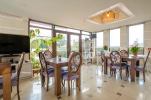 a dining room with a table and chairs and a television at Areti Suites in Kathiana