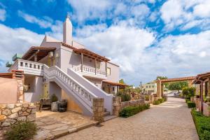 a white church with a steeple on a street at Areti Suites in Kathiana