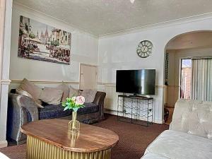 a living room with a couch and a tv at Bull Double bed in shared house in Stifford