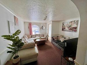 a living room with a couch and a tv at Bull Double bed in shared house in Stifford