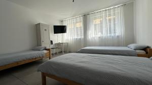 a bedroom with two beds and a tv in it at Zimmervermietung Aras in Paderborn
