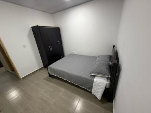 a bedroom with a bed and a black cabinet at Aparta hotel Brisas de salento in Salento