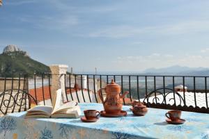 un tavolo con un libro, una teiera e libri di Villa Maddalena a Baunei