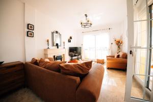 a living room with a brown couch and a television at Villa Dahi Almerimar 10 Guest, Prive Pool, Prive Bar, BBQ, Sea Views in Almerimar