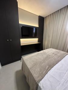 a bedroom with a bed and a flat screen tv at Apto Cancún Foz in Foz do Iguaçu +1 photo