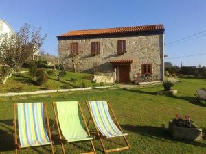 two lawn chairs sitting in front of a house at A Cantaruxa Maruxa Turismo Rural in Mondariz