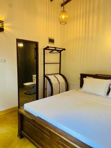 a bedroom with a bed and a bathroom with a toilet at Villa 66 Ahangama in Ahangama