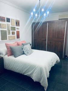 a bedroom with a large white bed with a chandelier at Las Fadrique in Córdoba