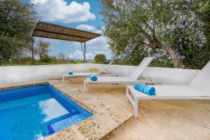 a swimming pool with two lounge chairs next to a swimming pool at Fora Vila in Manacor
