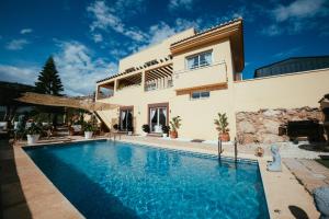 a villa with a swimming pool in front of a house at Villa Dahi Almerimar 10 Guest, Prive Pool, Prive Bar, BBQ, Sea Views in Almerimar