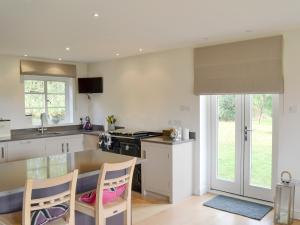 a kitchen with a table and some chairs in it at Brookside Cottage in Burley