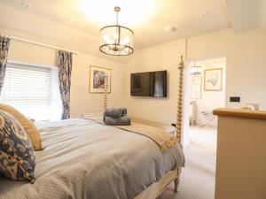 a bedroom with a large bed and a tv at 6 Uppergate Street Rose Cottage in Conwy
