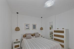 a white bedroom with a bed and a dresser at Costa azul in Los Llanos de Aridane