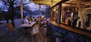 a group of people sitting at a table at a restaurant at Shamba Pori Lodge in Idulo