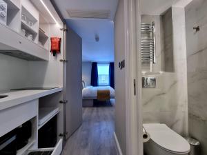 a bathroom with a toilet and a bed in a room at West Brompton Studios in London