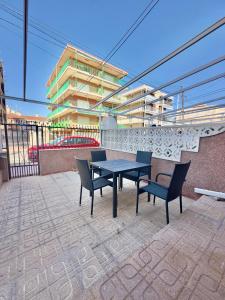 a table and chairs on a patio with a building at Bungalow Monover Playa in Santa Pola