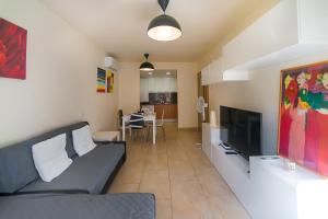 Una sala de estar con un sofá y un televisor de pantalla plana. en WELCS APARTAMENTO 209 PDA en Palafrugell, en Palafrugell