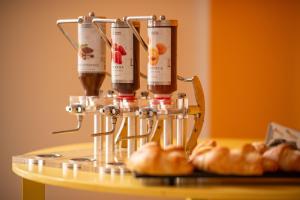 a coffee machine with three bottles on top of a table at Ostello Stella Del Mare in Varazze