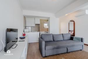 a living room with a couch and a kitchen at Ericeira Panoramic Sea View Apartments in Ericeira