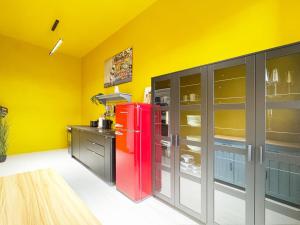 a kitchen with a red refrigerator in a yellow wall at Platanenblick in Schönebeck an der Elbe in Schönebeck