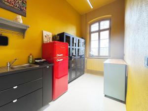 a kitchen with a red refrigerator and a sink at Platanenblick in Schönebeck an der Elbe in Schönebeck