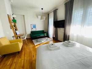 a bedroom with a bed and a chair and a couch at 19 Living in Komotini