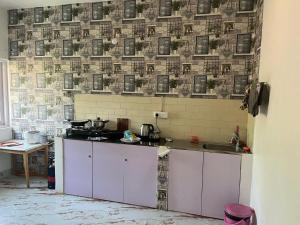 a kitchen with purple cabinets and a tile wall at Dream Dwell Resort in Calangute