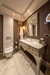a bathroom with a sink and a toilet and a mirror at MFB Tarabya Hotel in Istanbul