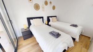 2 Betten in einem Zimmer mit weißen Wänden und Holzböden in der Unterkunft Casa Velapi - A Murcia Holiday Rentals Property in Roda + 16 Fotos