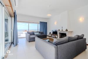 a living room with two couches and a fireplace at Ericeira Panoramic Sea View Apartments in Ericeira
