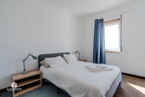 a bedroom with a bed and a window at Ericeira Panoramic Sea View Apartments in Ericeira