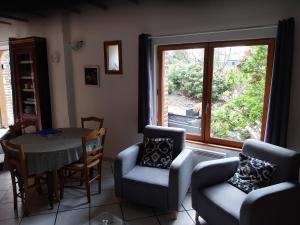 a living room with a table and chairs and a window at Les Noisettes Sauvages proche Etretat in Villainville
