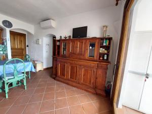 salon z telewizorem na górze drewnianej szafki w obiekcie "Sardinia Blue Home" Vista mare, tramonti mozzafiato su Golfo Asinara, giardino, parking e Wi-Fi w mieście Castelsardo