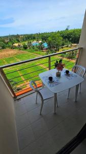 een witte tafel en stoel op een balkon met uitzicht bij Sunset view studio at 777 Beach Condo in Ban Mai Salae