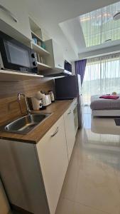 een keuken met een wastafel en een bed in een kamer bij Sunset view studio at 777 Beach Condo in Ban Mai Salae