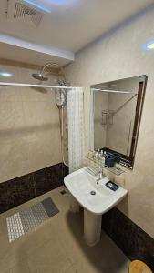 een badkamer met een wastafel, een douche en een spiegel bij Sunset view studio at 777 Beach Condo in Ban Mai Salae