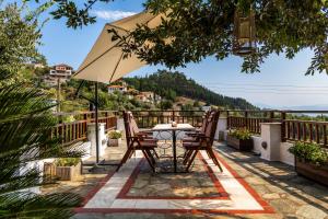 un tavolo e delle sedie sul balcone di una casa di Pelion Luxury Villa Ivy ad Áno Vólos