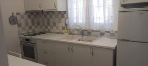 a small kitchen with a sink and a refrigerator at Anna -House Maria Manolaki, 2-Βedrm Apartment in Vourvourou +62 photos