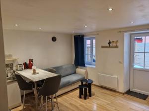 a living room with a couch and a table at La Petite Bressane in Bourg-en-Bresse