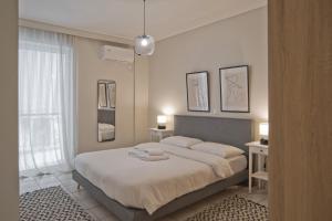 una camera da letto con un letto con due asciugamani sopra di Denimou Home Luxurious 2BR Fully Equipped, Balcony a Pireo