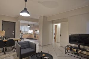 un soggiorno con divano, tavolo e TV di Denimou Home Luxurious 2BR Fully Equipped, Balcony a Pireo