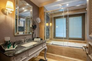 a bathroom with a tub and a sink and a shower at MFB Tarabya Hotel in Istanbul