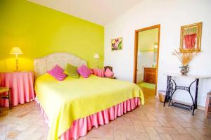 a bedroom with a large bed with pink and yellow sheets at Elegant Villa in Loulé with Private Pool in Loulé +37 photos