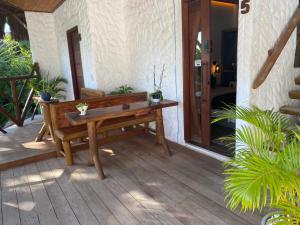 a wooden bench sitting on the porch of a house at Casa Palmeira in Pipa