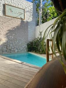 a swimming pool with a bench next to a building at Casa Palmeira in Pipa