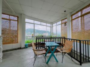 a dining room with a table and chairs on a balcony at The Kandy Home & City mirror Hostel in Kandy