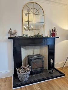 a fireplace with a mirror on top of it at Glenrigh House - Main Residence for 7 people in Onich